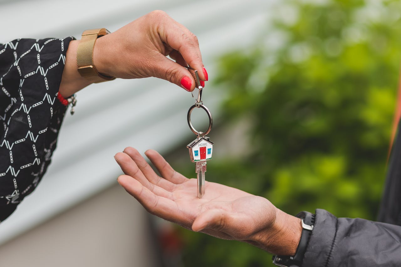 The Art of Drawing Readers In: Your attractive post title goes here Close-up of a hand handing over a key with a house keychain, symbolizing real estate transaction.